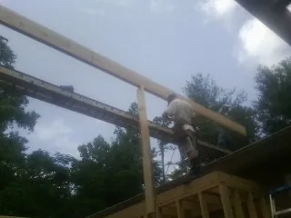 Carpenter setting a ridge beam over a new addition frame — Ice Dam Removal by Roofing Brothers in Decherd