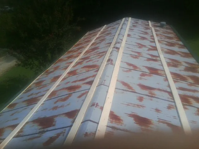 Rusted metal roof panels with new wood purlins before replacement — Storm Damage Roof Repair in Decherd by Roofing Brothers