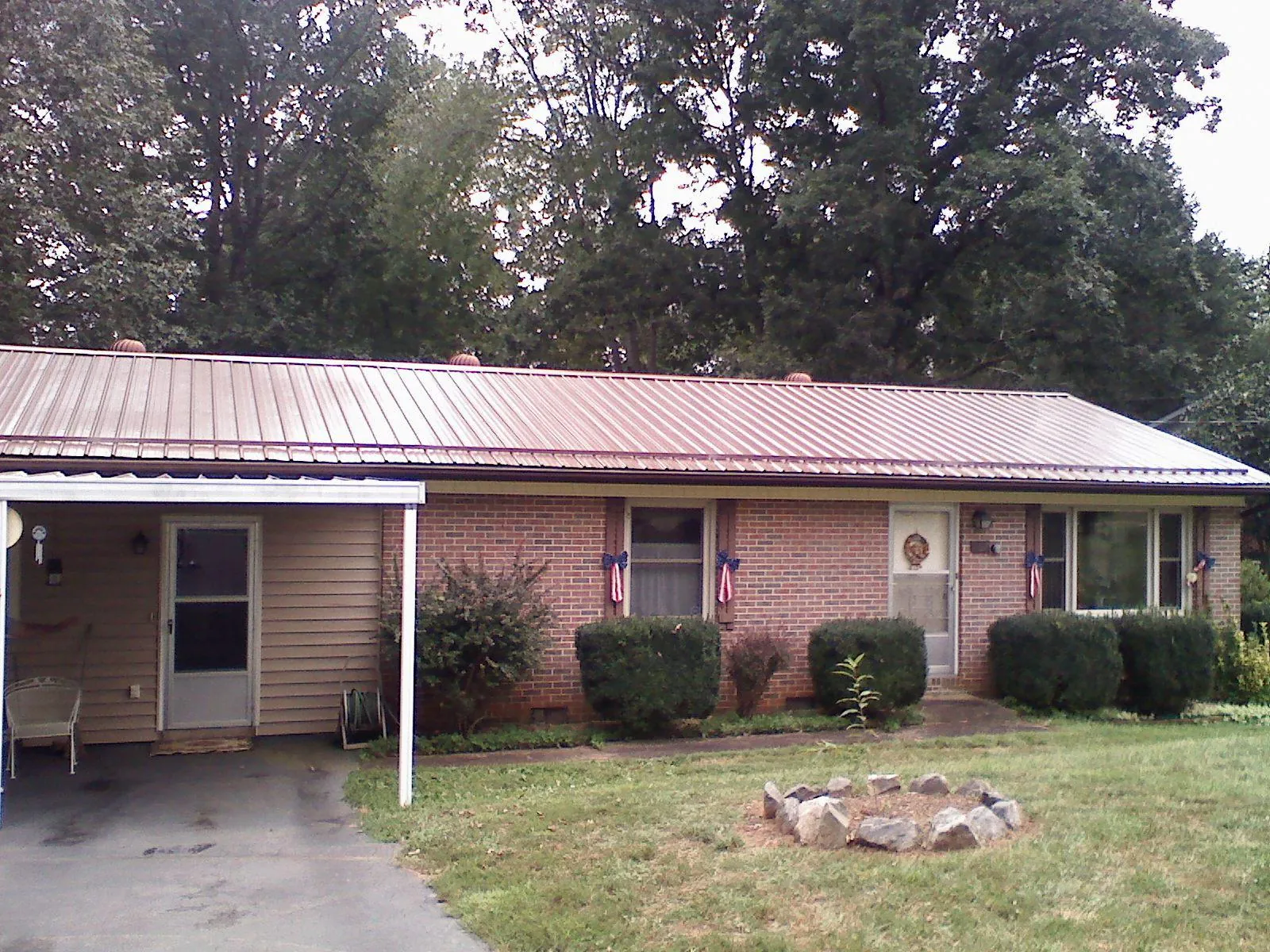 Bronze metal roof and carport on a brick ranch home — Roof Repair work by our crew in Decherd